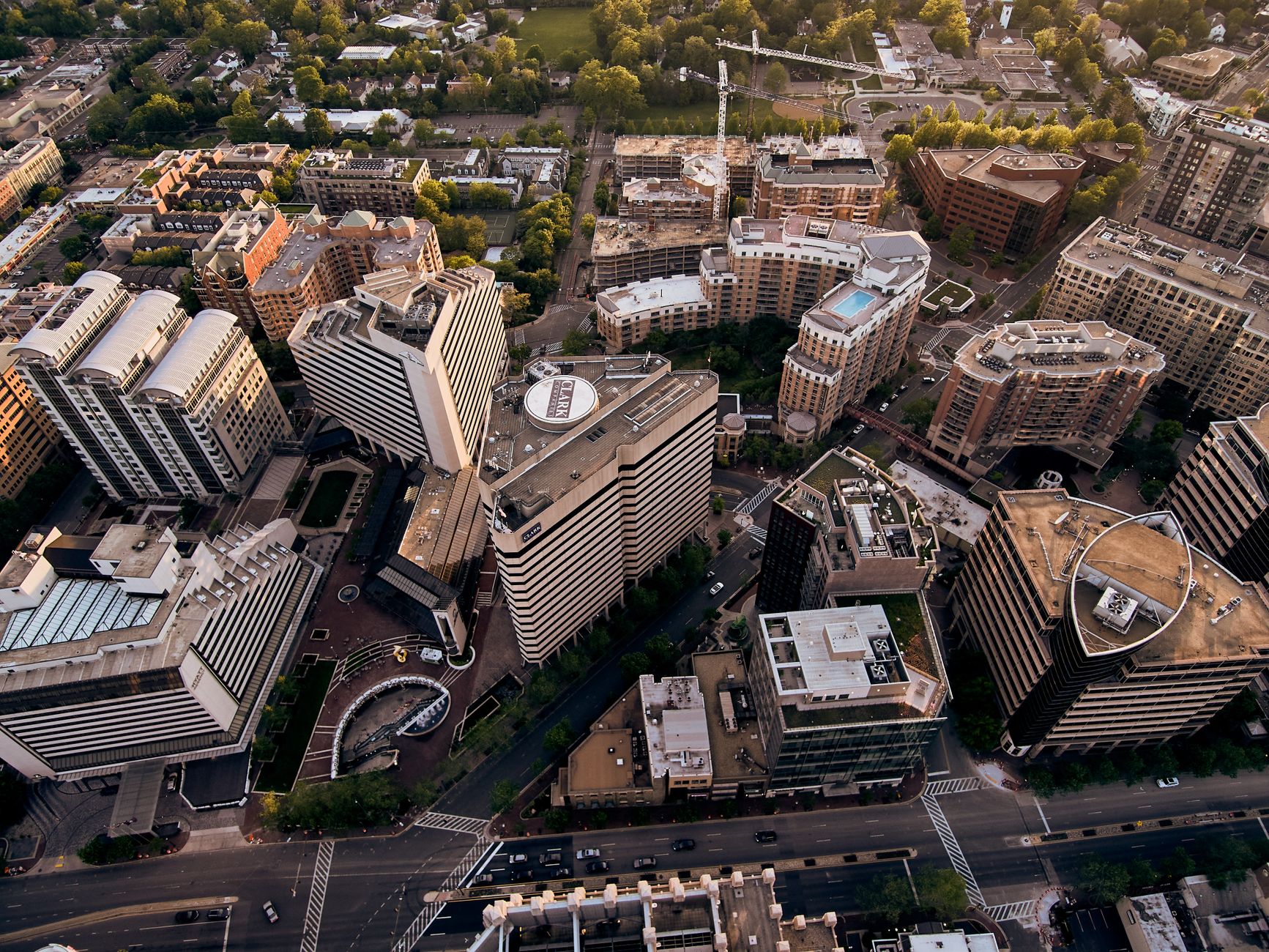 Drone view of creative geometric buildings and green areas in residential district of modern city