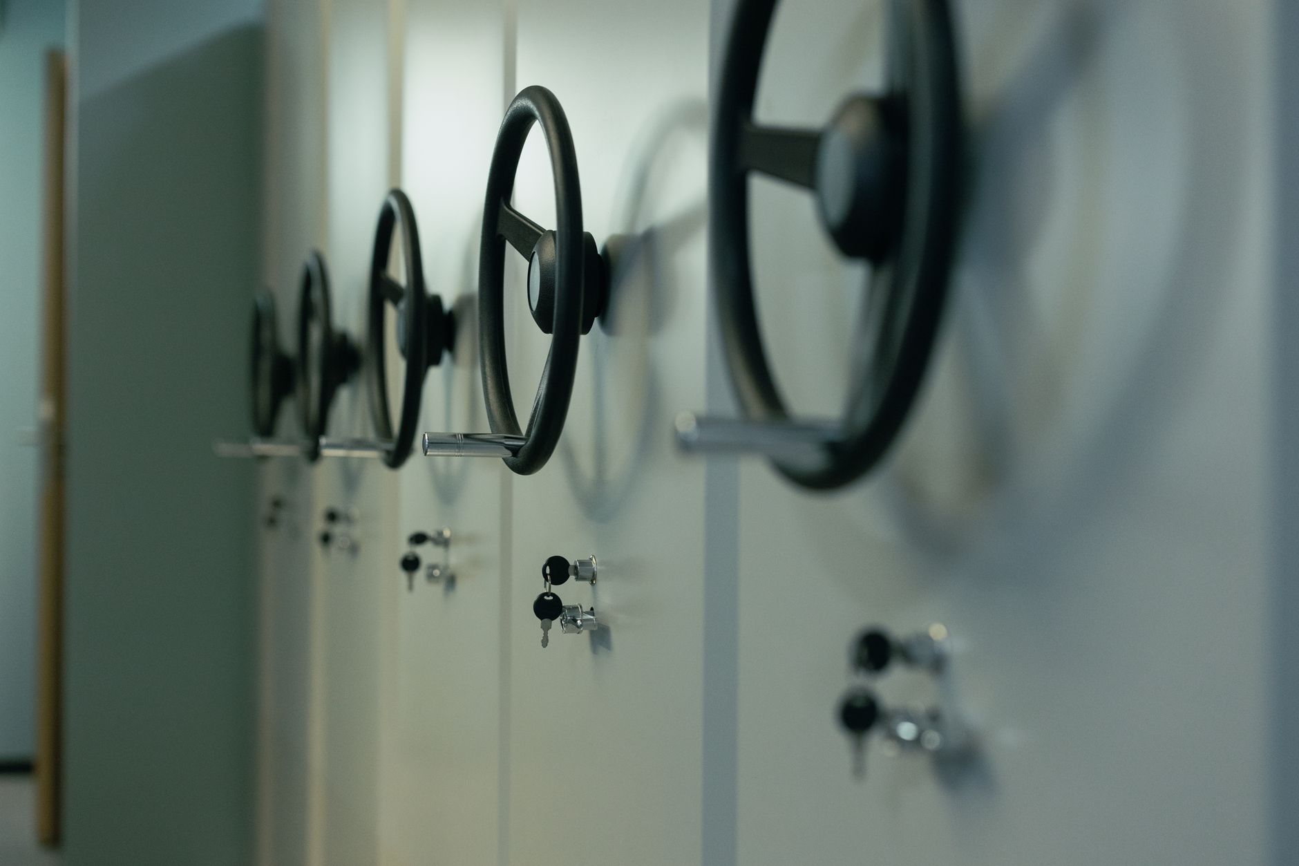 A row of steel safe doors with wheel handles and keys