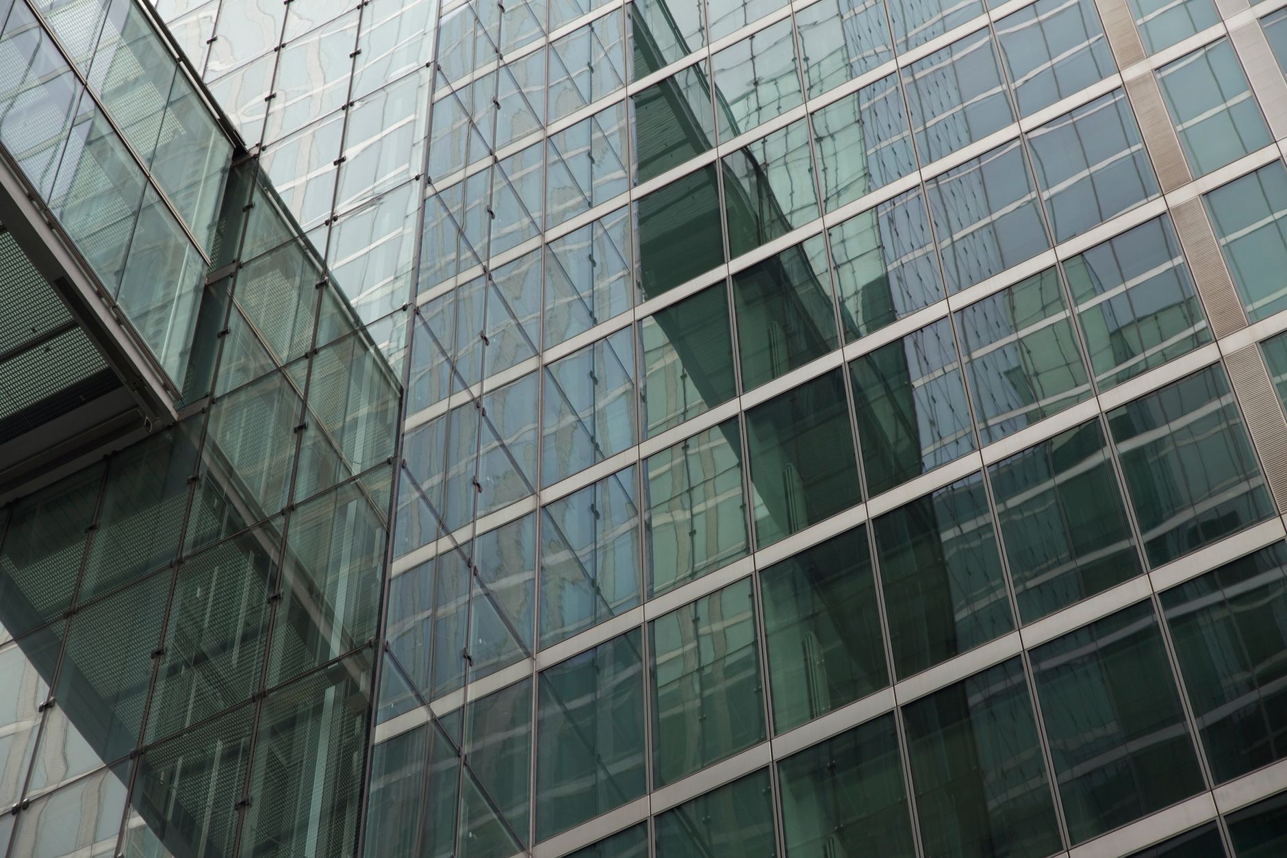 Detailed view of a modern building facade with reflective glass windows, capturing urban architecture.