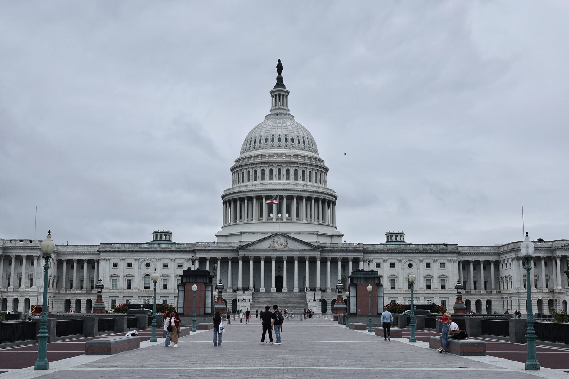 A grand shot of the United States Capitol in Washington D.C. with visitors in the foreground.
